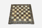 Top-down view of the empty brown and cream marble chess board with brass coordinate markers