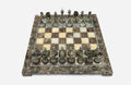 Brown marble chess set with hand-cast bronze pieces arranged for play and brass coordinate markers