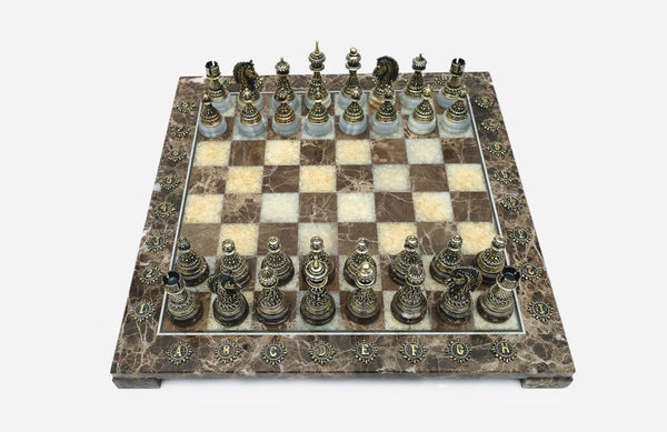Brown marble chess set with hand-cast bronze pieces arranged for play and brass coordinate markers