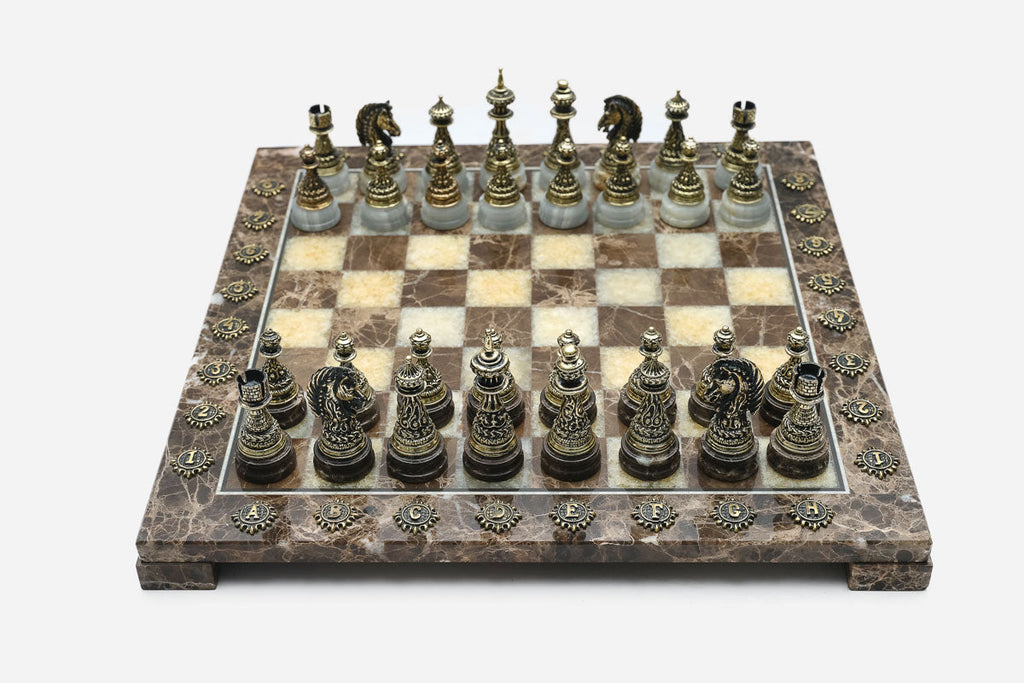 Brown and cream marble chess set viewed from the front with ornate bronze pieces