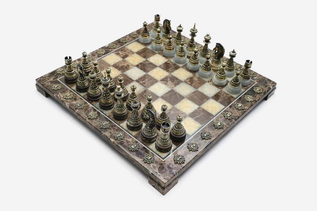 Elevated view of the brown marble chess board with bronze pieces and brass coordinate markers