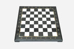 Top-down view of the empty black and white marble chess board with brass coordinate markers