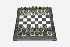 Black and white marble chess set viewed from the front with bronze pieces ready to play