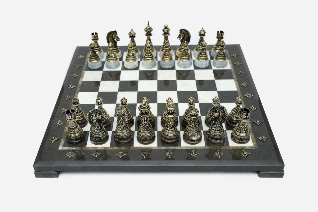 Black marble chess set with hand-cast bronze pieces arranged for play and brass coordinate markers