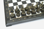Close-up of the ornately cast bronze chess pieces on the black and white marble board