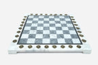 Front view of the grey and white marble chess board framed by brass coordinate markers