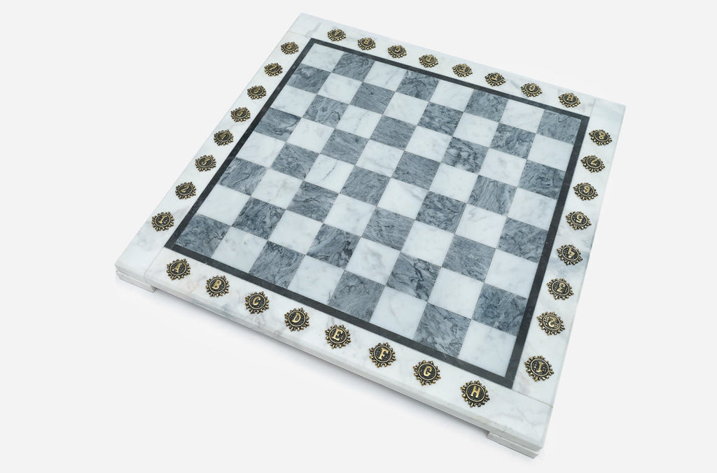 Angled view of the empty grey marble chess board with brass letter and number markers