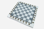 Angled view of the empty grey marble chess board with brass letter and number markers