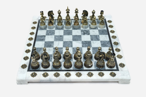 Grey and white marble chess set with hand-cast bronze pieces arranged for play and brass coordinate markers