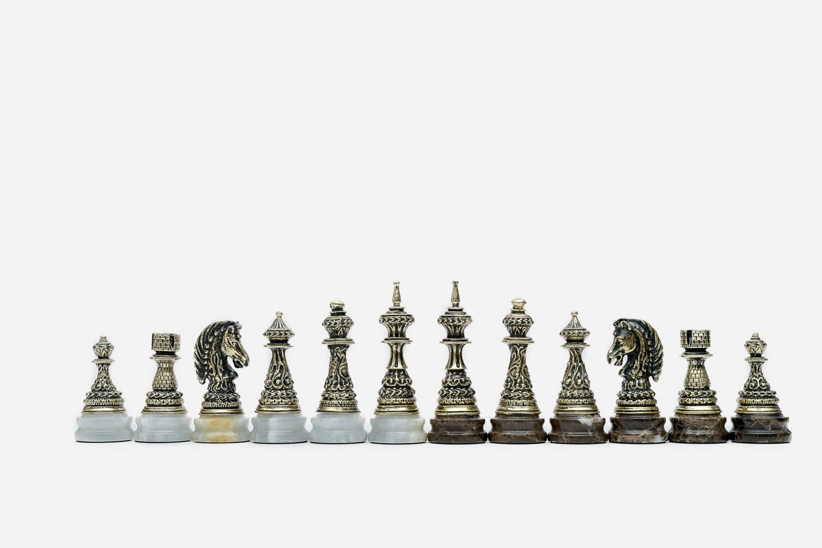 Full row of the hand-cast bronze chess pieces showing kings, queens, bishops and horse-head knights