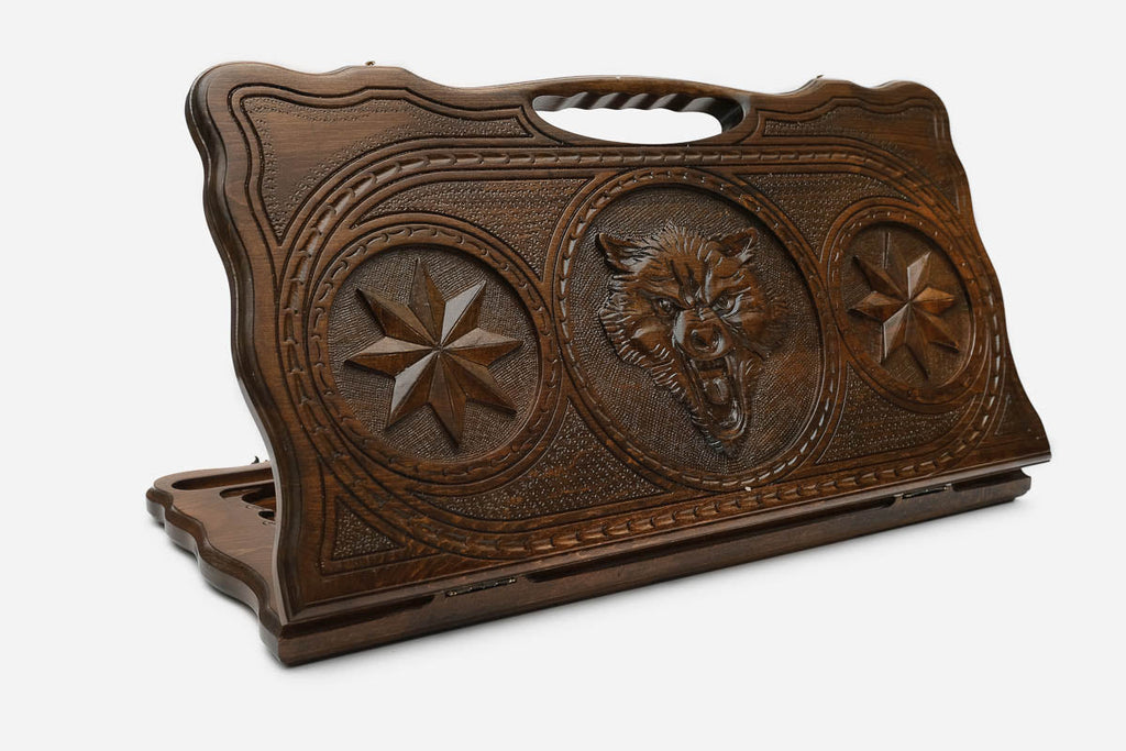 Carved beechwood backgammon board with a fierce wolf between carved stars, propped open