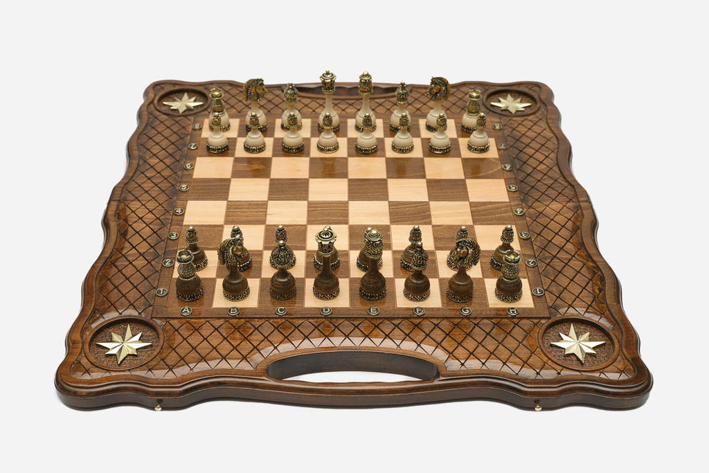 Luxury carved chess set with four inlaid brass stars, lattice borders and ornate bronze pieces set up for play