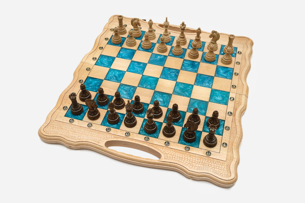 Angled view of the turquoise epoxy chess set with its carved wooden pieces