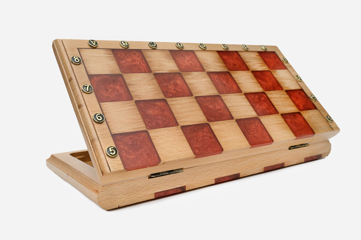 Angled view of the red epoxy chess set with its bronze pieces