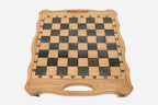 Close-up of the ornate bronze chess pieces on cream and walnut bases
