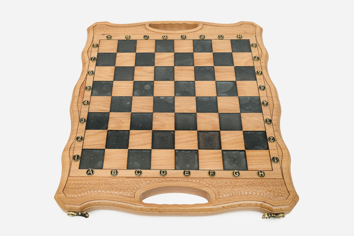 Close-up of the ornate bronze chess pieces on cream and walnut bases