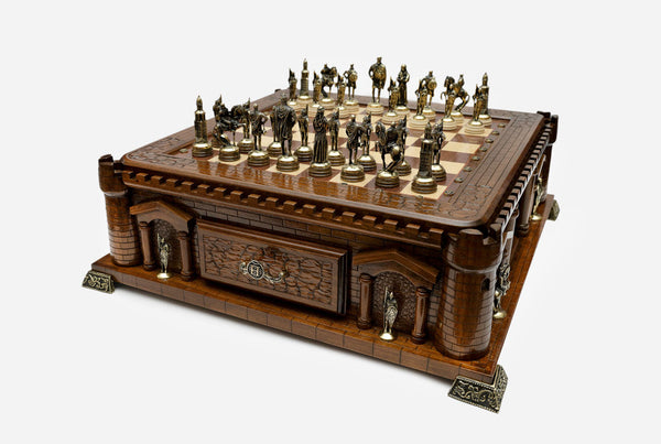 Castle chess set with bronze pieces set up on the board, angled view
