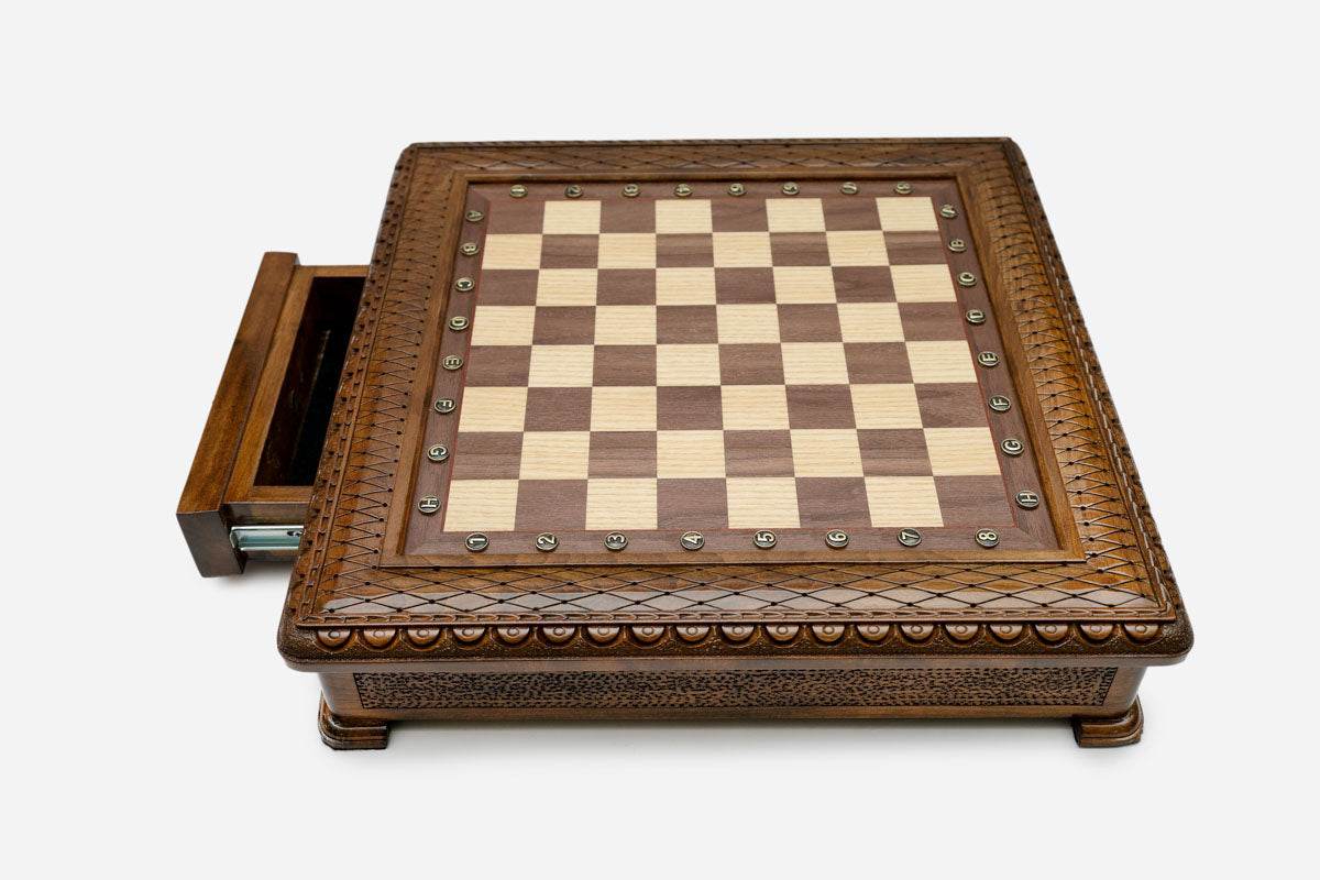 Carved chess set with wood pieces set up for play, front view