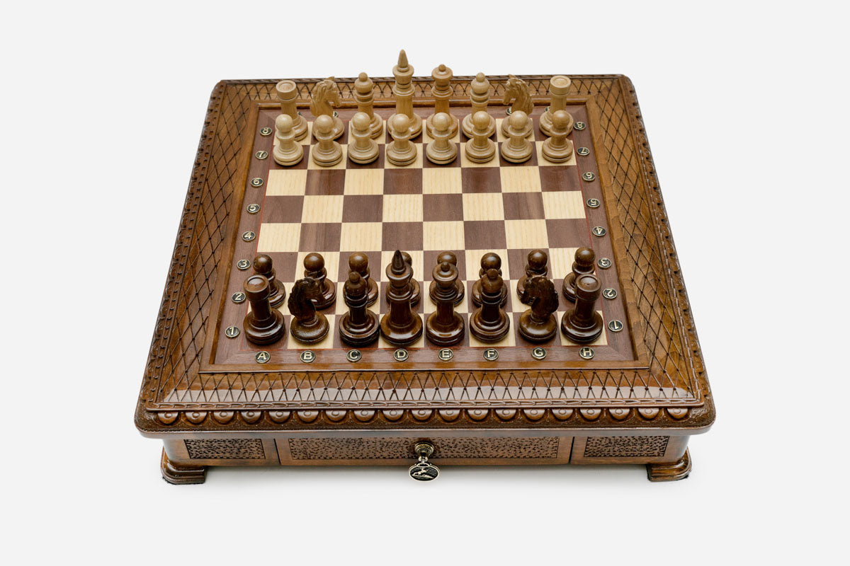 Carved chess set empty board with the storage drawer open, angled view