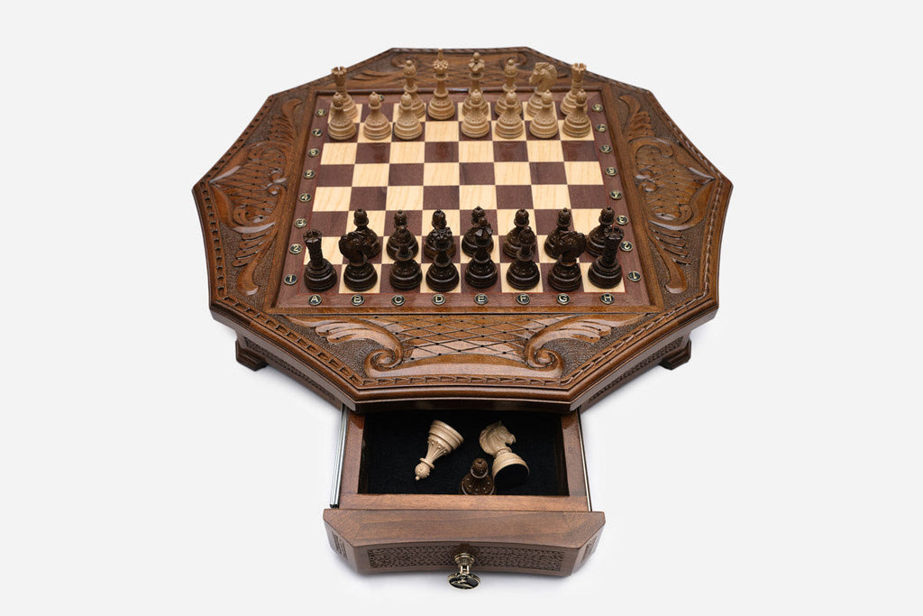 Octagonal chess set with the storage drawer open showing the carved wooden pieces inside