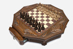 Angled view of the octagonal chess set with its storage drawer open and carved pieces on the board