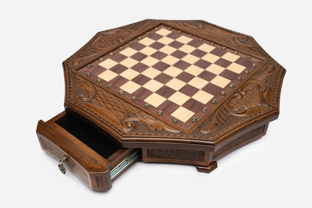 Octagonal chess set in honey-walnut finish, top angle showing ornate carved pieces arranged on the inlaid board