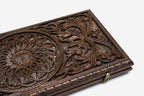 The carved board partly open, showing its hinged case form