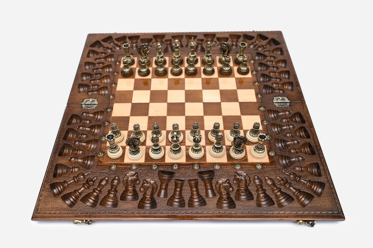 Luxury chess backgammon set opened with ornate bronze pieces set up, framed by a deeply carved border