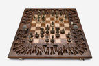 Close-up of the ornate bronze chess pieces with sculpted crowns and pale bases