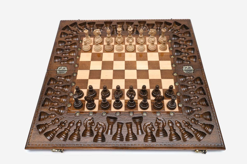 Angled view of the relief-carved chess set with its bronze figural pieces