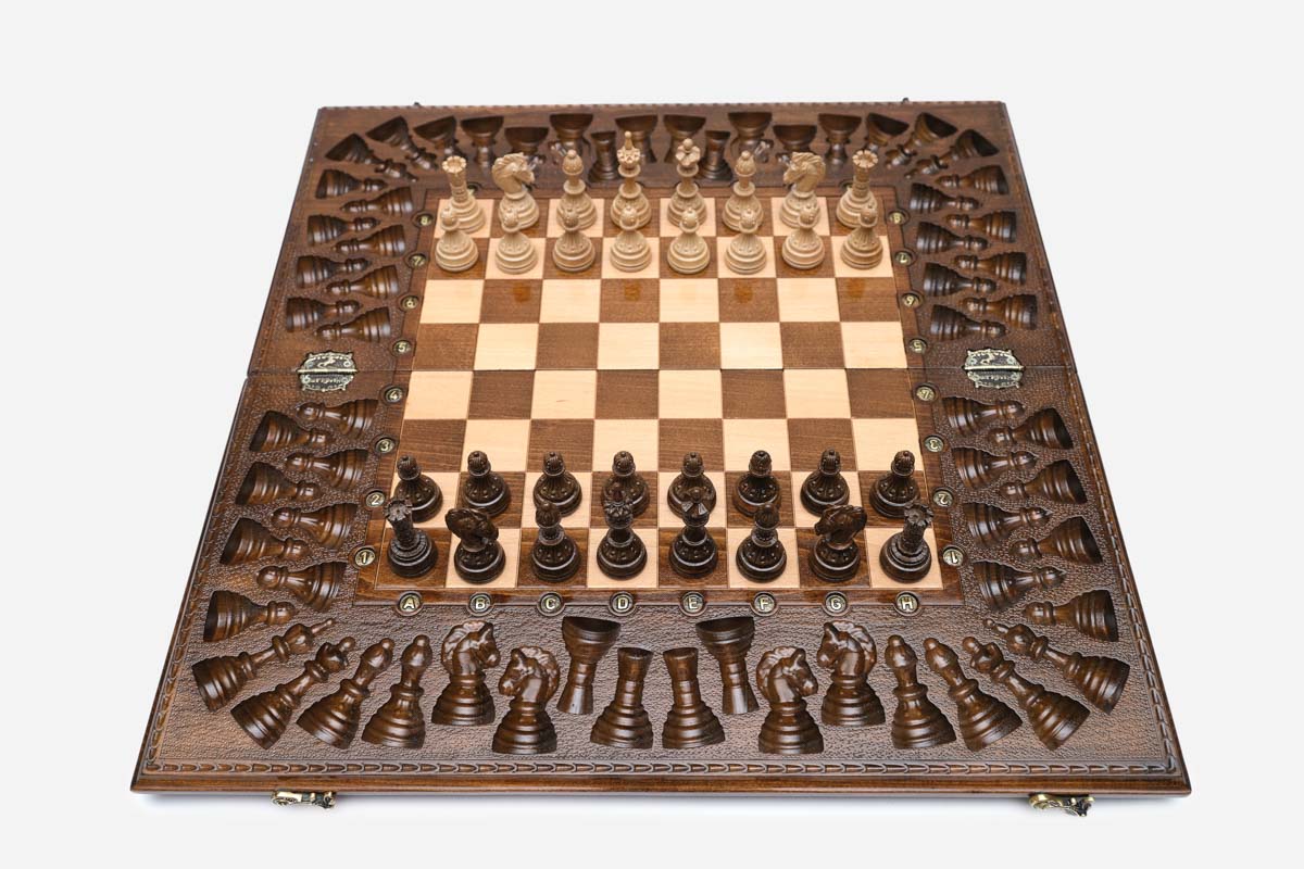 Angled view of the relief-carved chess set with its bronze figural pieces