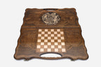 Angled view of the handmade Armenian backgammon set showing the bronze emblem on the carved lid
