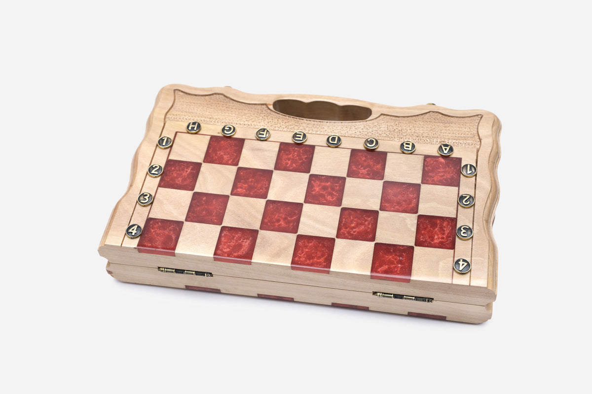 The compact red epoxy chess set shown from an angle