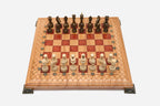 Folding chess board in pale wood with red epoxy squares, brass corner brackets and wooden pieces set up for play