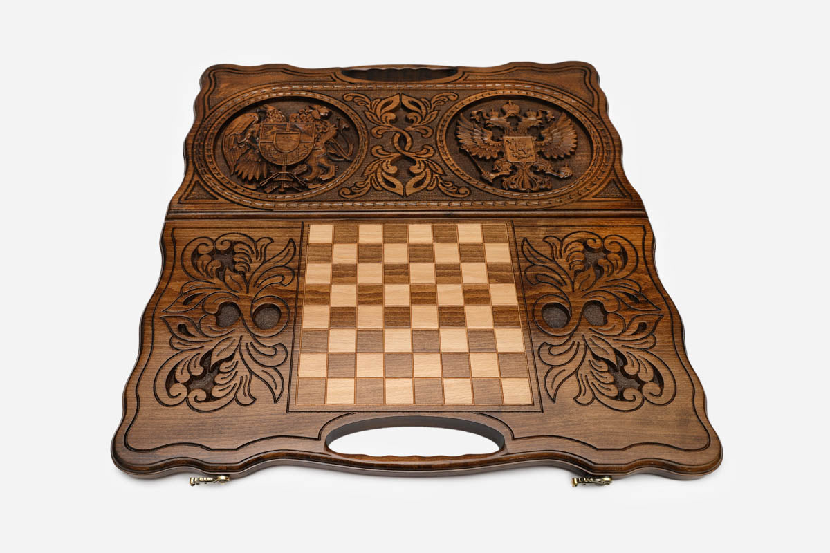 Angled view of the handmade backgammon set showing both carved emblems on the lid