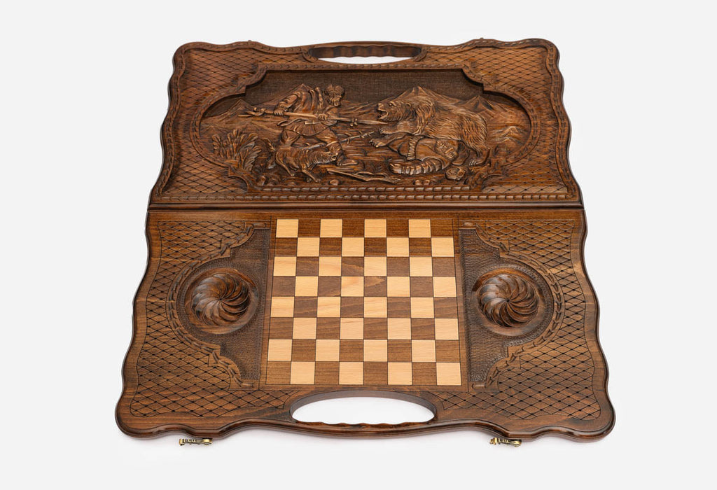 Angled view of the luxury handmade backgammon set showing the carved forest scene