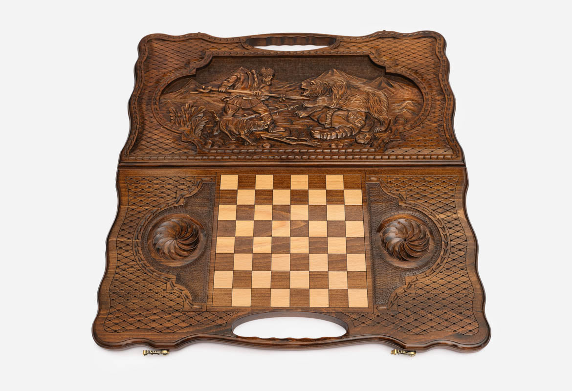Angled view of the luxury handmade backgammon set showing the carved forest scene