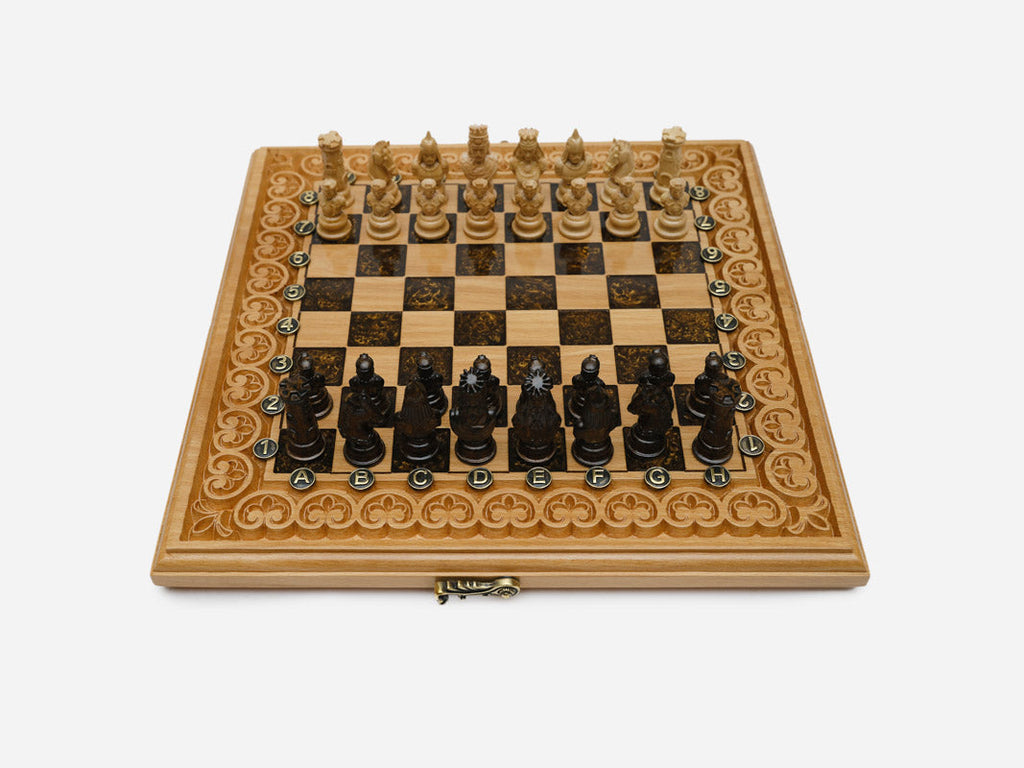 Luxury brown epoxy chess set with figural carved pieces set up for play on its arch-bordered board