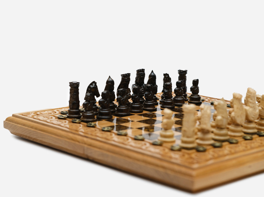 Close-up of the carved figural chess pieces in light and dark wood