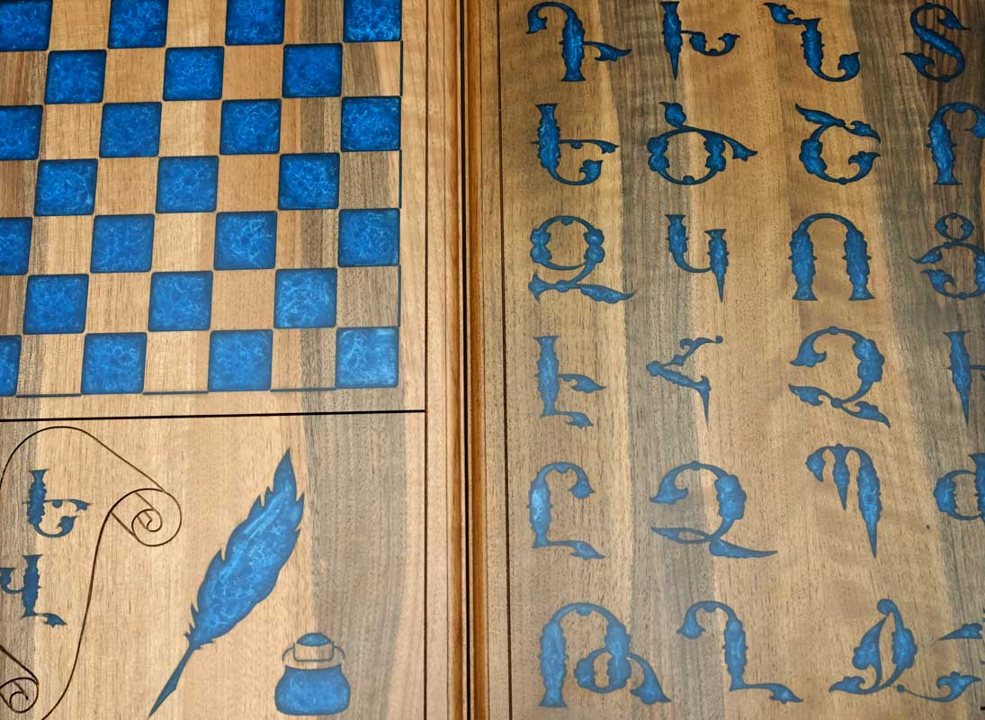 Close-up of the blue epoxy Armenian letters set into the walnut