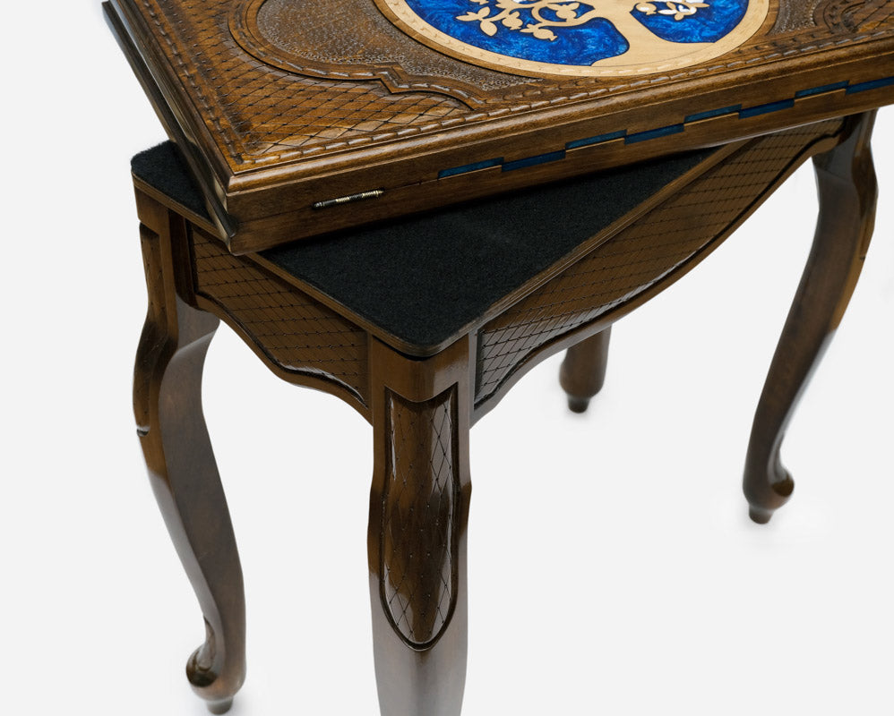 Side view of the handmade chess table on its four carved cabriole legs