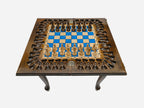 Close-up of the turned wooden chess pieces standing on the blue epoxy squares
