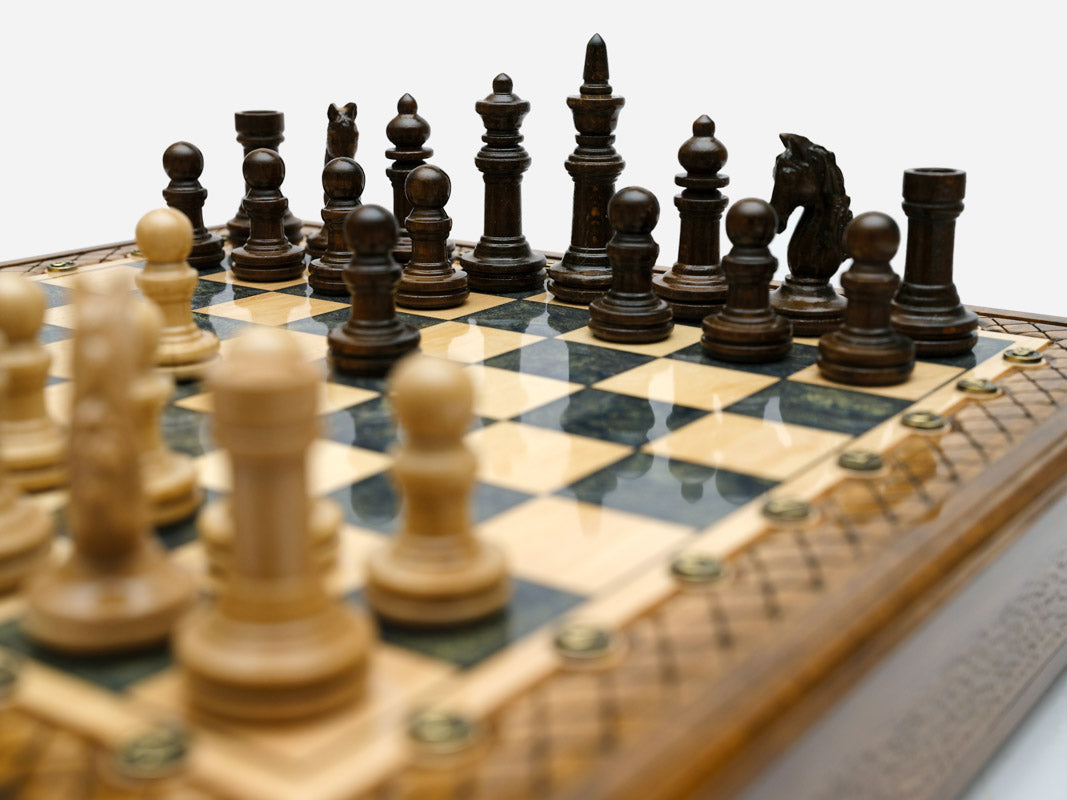 Close-up of the wood chess pieces on the gray epoxy board