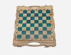 Detail of the ornate bronze chess pieces with sculpted crowns and cream epoxy bases