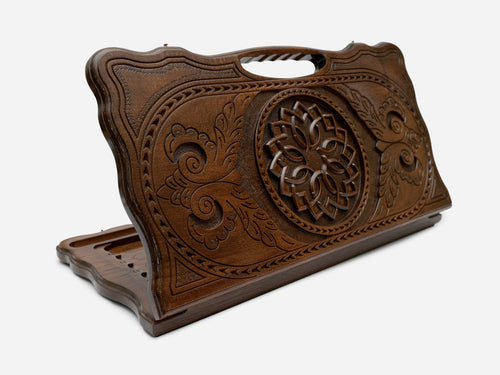 Carved Armenian backgammon board with a blossom and trailing vines and a cut-out carry handle, propped open