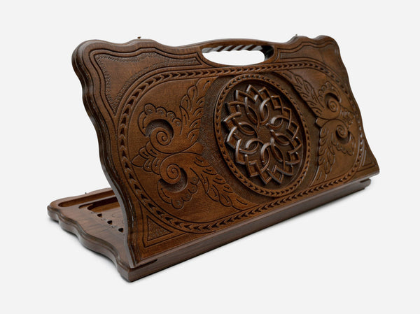 Carved Armenian backgammon board with a blossom and trailing vines and a cut-out carry handle, propped open