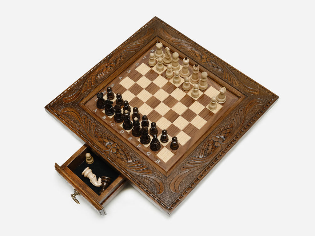 Carved chess set top-down view with the front drawer open and pieces set up