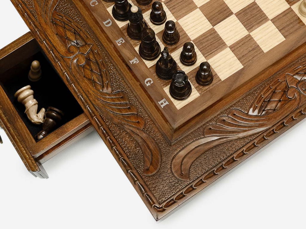 Close-up of a side drawer open with wood chess pieces stored inside