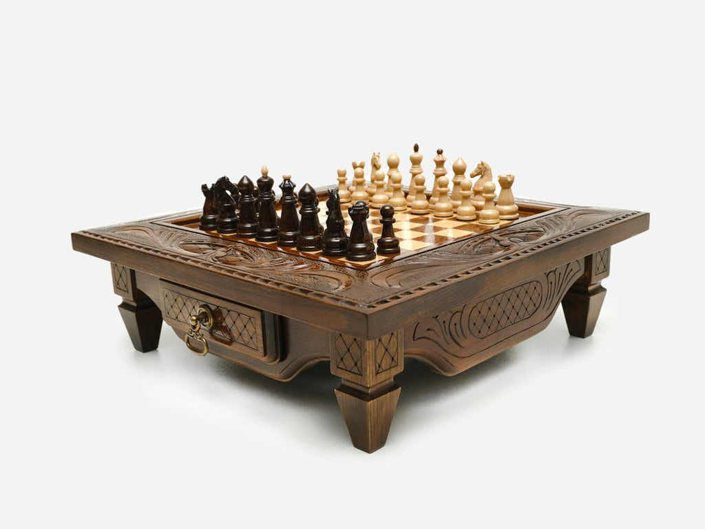 Carved chess set on short legs with the front drawer open, angled view