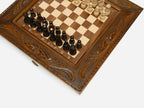 Close-up of the carved frame corner and wood chess pieces